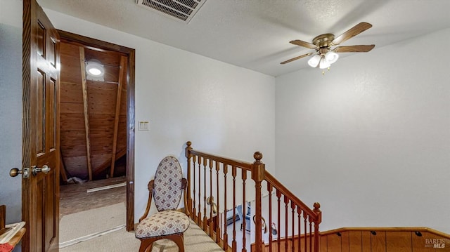 staircase with ceiling fan and carpet floors