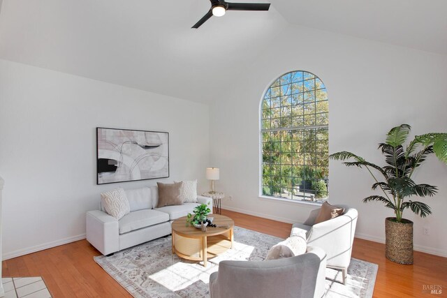 living room featuring ceiling fan, lofted ceiling, and light hardwood / wood-style flooring