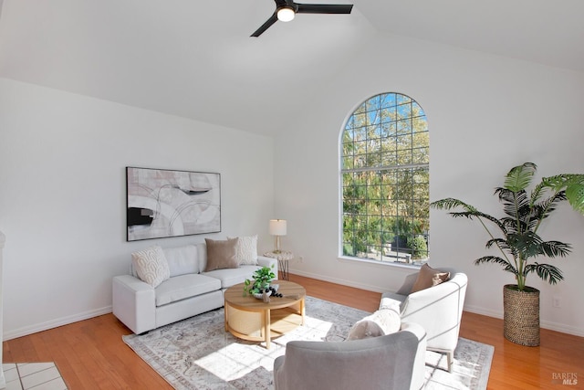 living area with a ceiling fan, lofted ceiling, baseboards, and wood finished floors