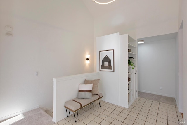 living area with light carpet, high vaulted ceiling, and baseboards