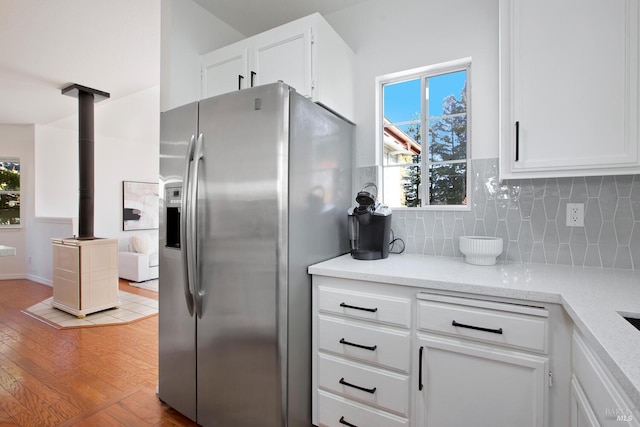 kitchen with tasteful backsplash, a healthy amount of sunlight, stainless steel fridge, and light wood-style flooring