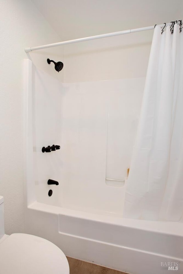 full bath with toilet and shower / tub combo with curtain