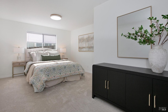 bedroom with baseboards and light colored carpet