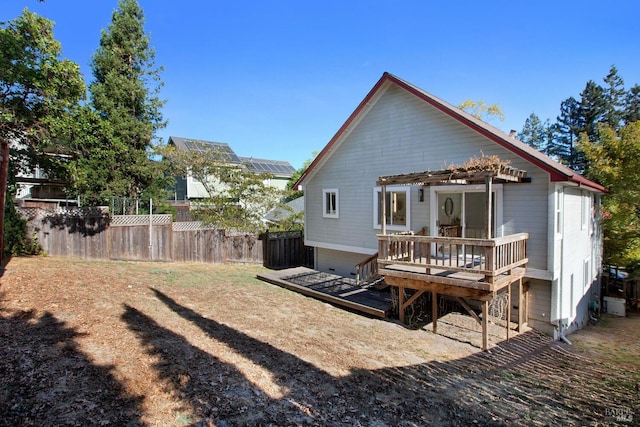 rear view of house with fence, a deck, and a pergola