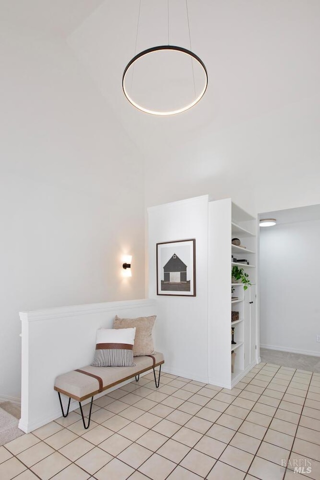 living area with light tile patterned floors and a towering ceiling