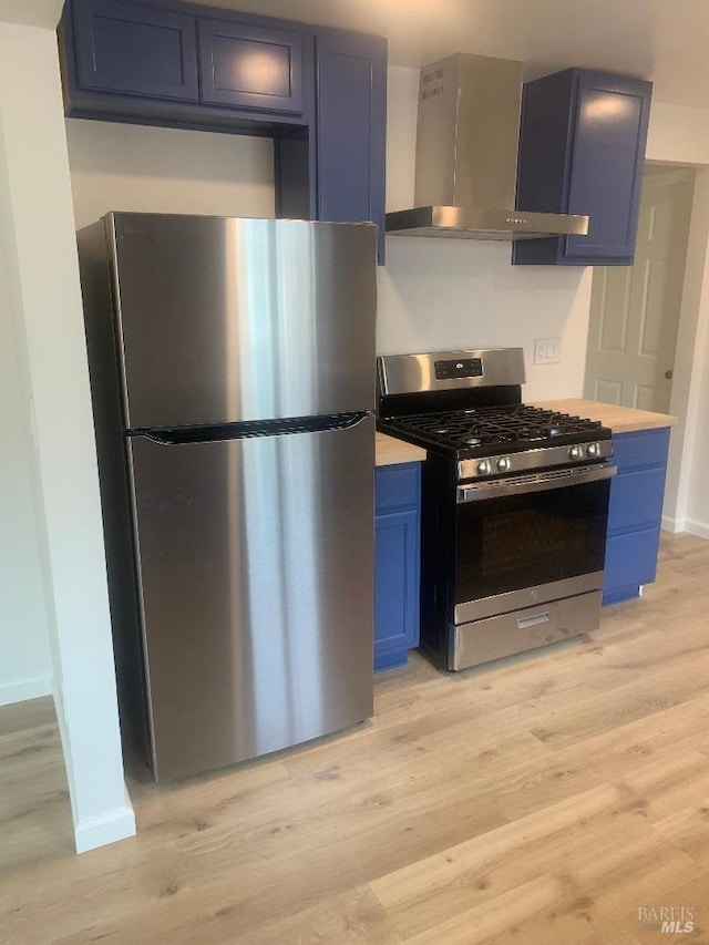 kitchen featuring wall chimney exhaust hood, blue cabinets, and stainless steel appliances