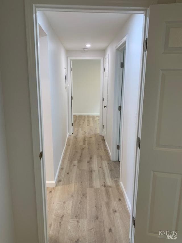 corridor with light hardwood / wood-style flooring