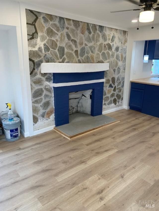 details featuring a fireplace, hardwood / wood-style flooring, and ceiling fan