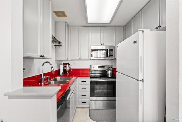 kitchen with appliances with stainless steel finishes, sink, and light tile patterned floors