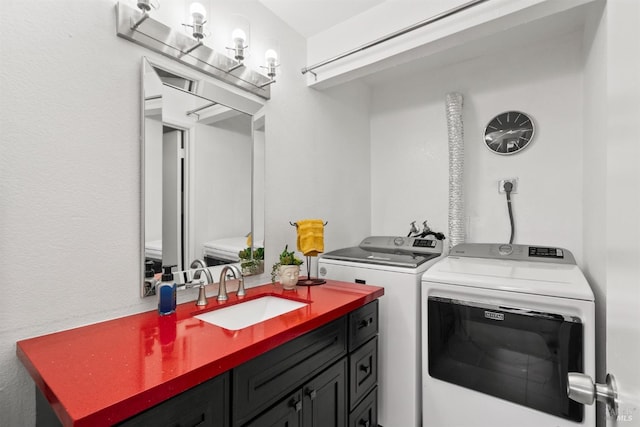 clothes washing area featuring sink and separate washer and dryer