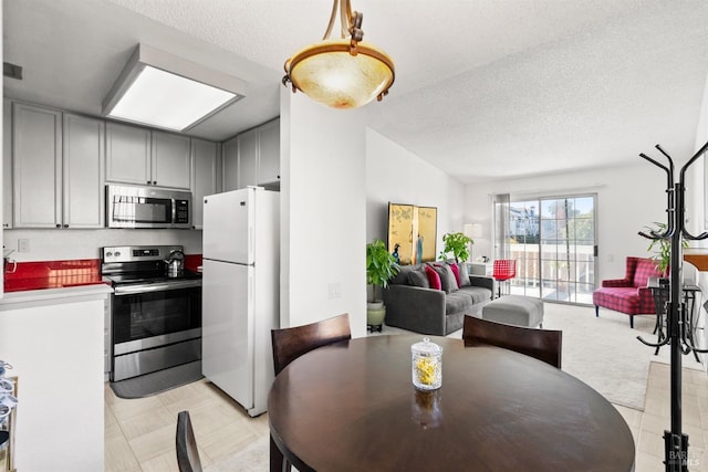 dining area featuring a textured ceiling and vaulted ceiling