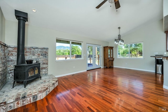 living room featuring lofted ceiling, dark hardwood / wood-style flooring, and ceiling fan with notable chandelier