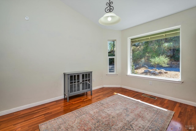 unfurnished room featuring dark wood-type flooring and vaulted ceiling