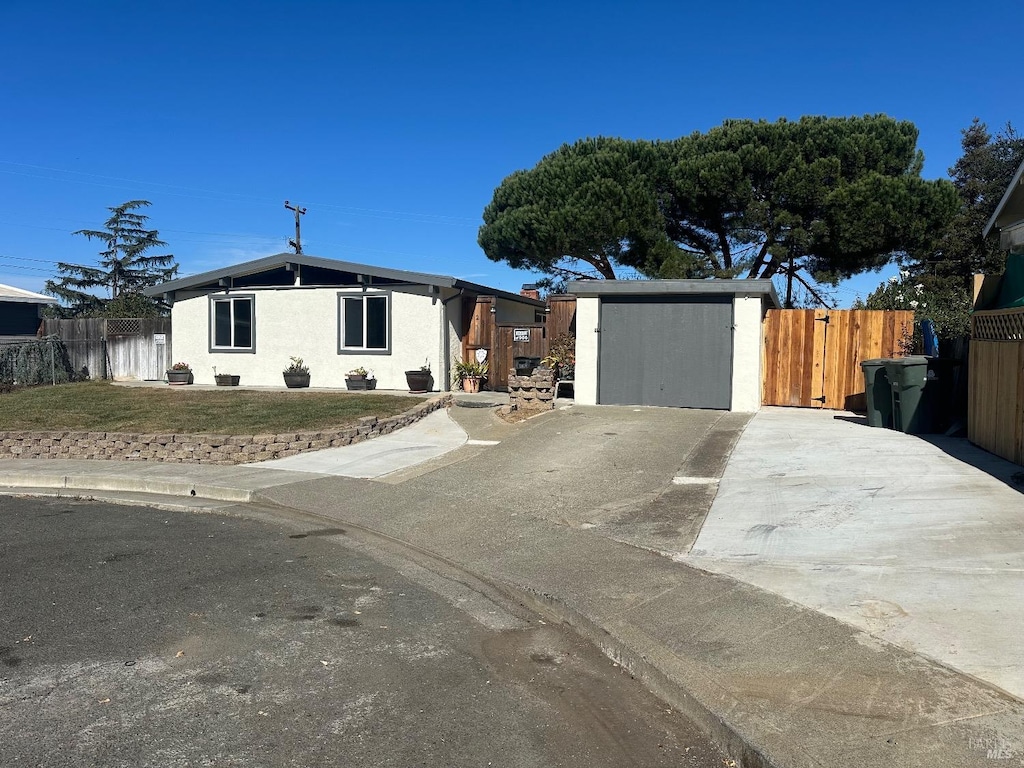 view of front of property featuring a storage shed and a front lawn