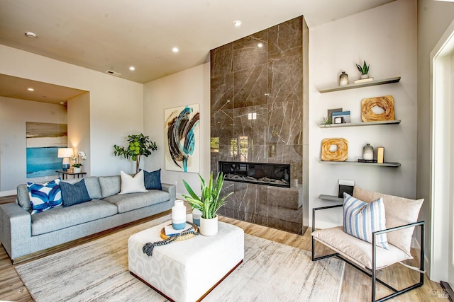 living room with a fireplace and light wood-type flooring