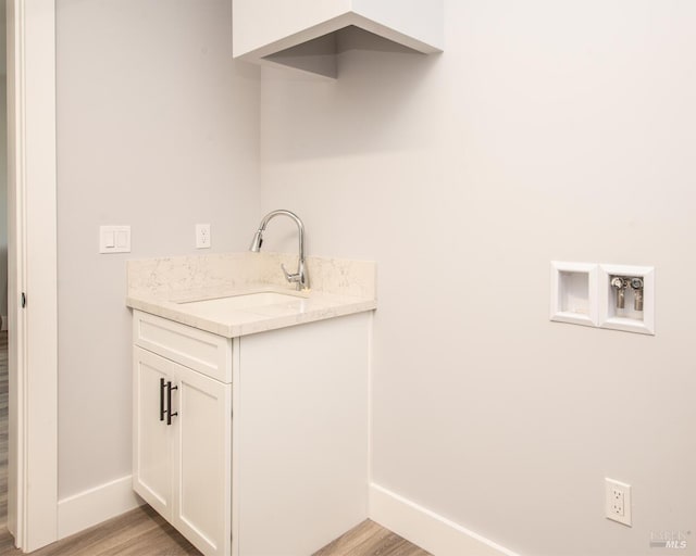 washroom featuring sink, light hardwood / wood-style flooring, and hookup for a washing machine