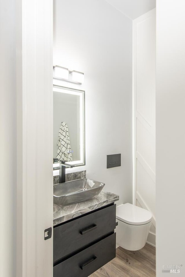 bathroom featuring vanity, hardwood / wood-style floors, and toilet