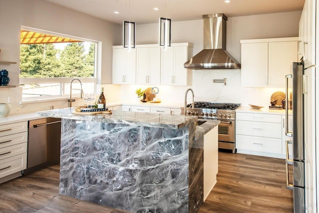 kitchen with wall chimney range hood, dark hardwood / wood-style floors, light stone countertops, white cabinetry, and appliances with stainless steel finishes