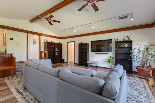 living room featuring vaulted ceiling with beams, ceiling fan, wood-type flooring, and a textured ceiling