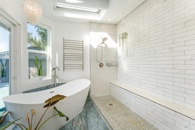 bathroom with shower with separate bathtub, a skylight, and radiator