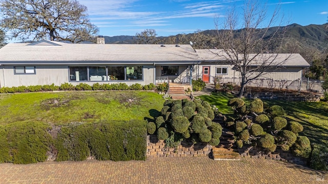 ranch-style home featuring a mountain view and a front yard