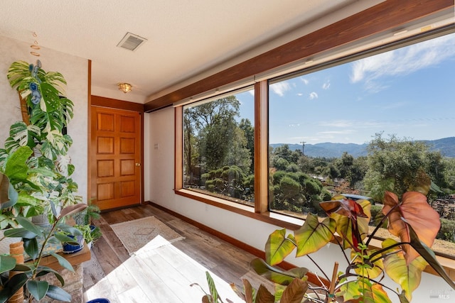 sunroom / solarium with a mountain view and plenty of natural light