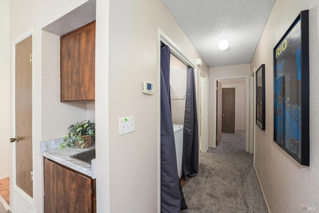 hallway with carpet and a textured ceiling