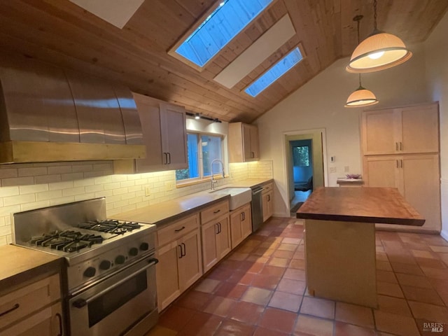 kitchen with wood counters, high vaulted ceiling, sink, appliances with stainless steel finishes, and decorative light fixtures