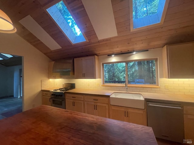 kitchen with sink, stainless steel appliances, wall chimney range hood, backsplash, and lofted ceiling with skylight