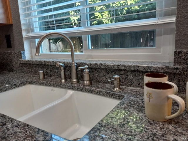 room details featuring sink and dark stone counters