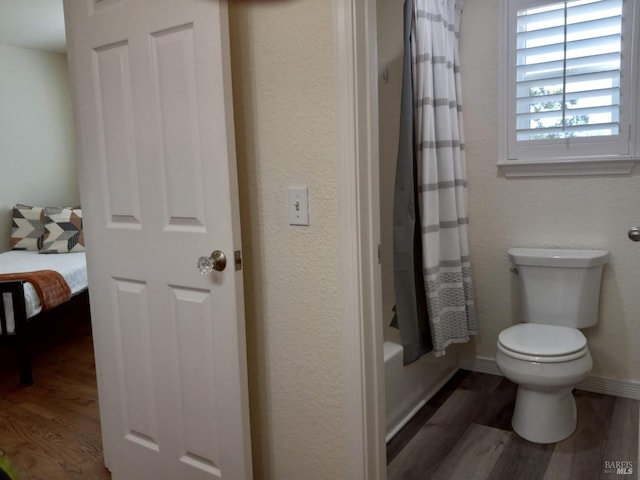 bathroom featuring toilet, shower / tub combo with curtain, and hardwood / wood-style flooring