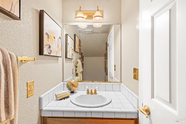 bathroom featuring vanity and a textured wall