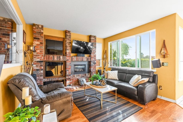 living room featuring light hardwood / wood-style floors and a brick fireplace