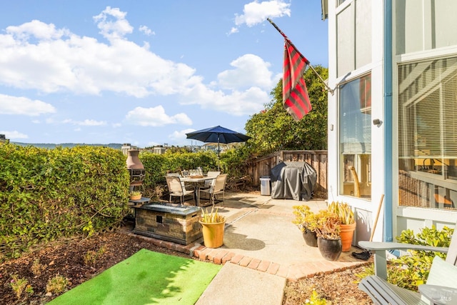 view of patio with grilling area, outdoor dining space, and fence