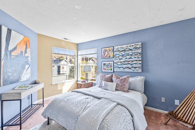 bedroom featuring carpet flooring, baseboards, visible vents, and a textured ceiling