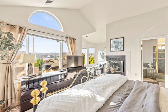 bedroom with visible vents, high vaulted ceiling, and a tiled fireplace