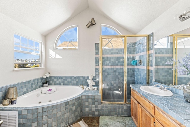 full bathroom featuring a shower stall, a jetted tub, plenty of natural light, and vaulted ceiling