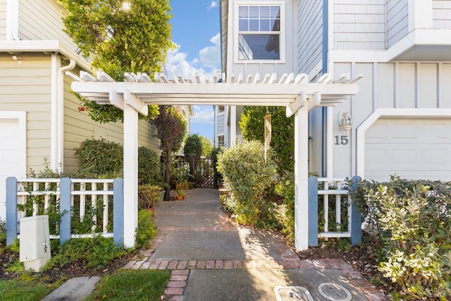 entrance to property featuring a garage and a pergola