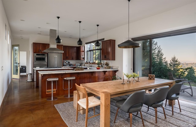 kitchen with sink, island range hood, kitchen peninsula, stainless steel double oven, and pendant lighting