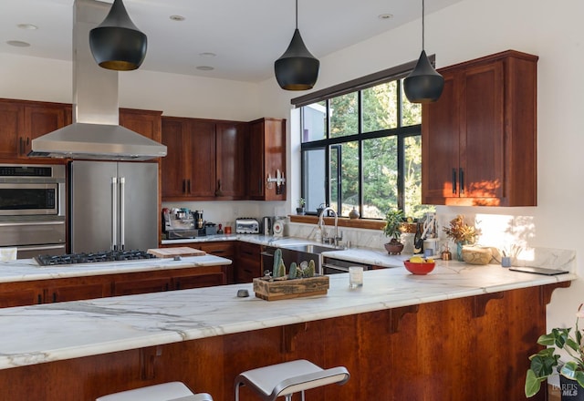 kitchen featuring appliances with stainless steel finishes, sink, island range hood, decorative light fixtures, and light stone counters