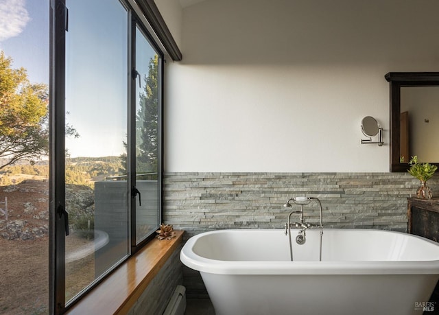 bathroom featuring tile walls and a bath