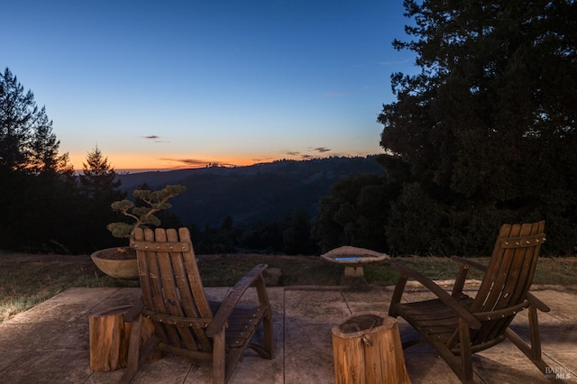 patio terrace at dusk featuring a mountain view