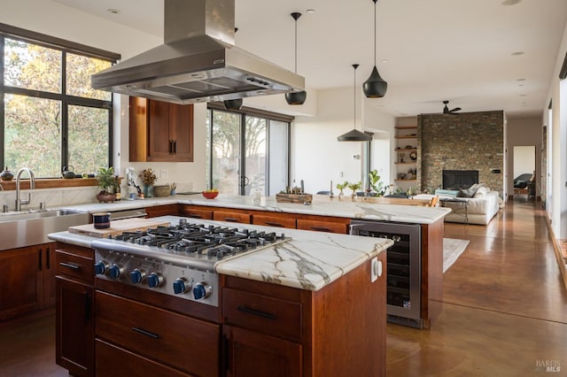 kitchen with stainless steel gas cooktop, plenty of natural light, a kitchen island, and island range hood