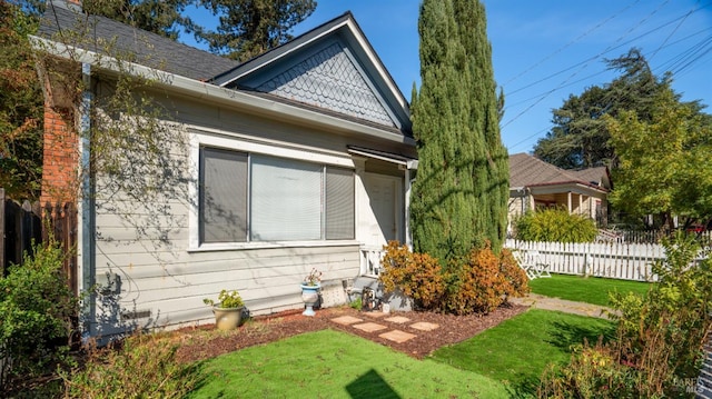 view of side of home with a yard