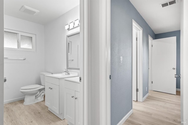 bathroom with hardwood / wood-style floors, vanity, and toilet