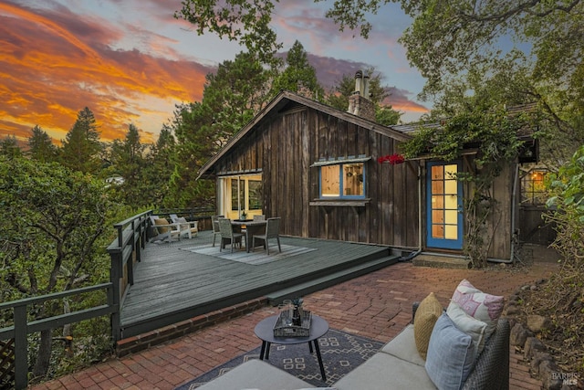 deck at dusk featuring an outdoor hangout area