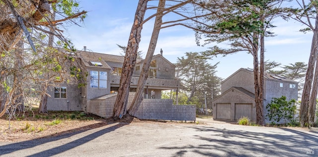 view of side of home with a garage and an outbuilding