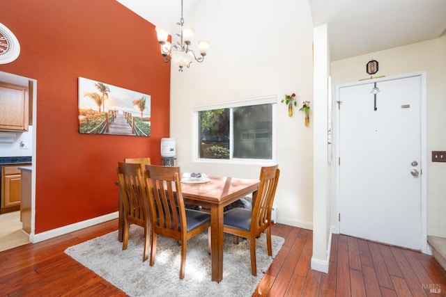 dining room featuring a high ceiling, a chandelier, and dark hardwood / wood-style flooring