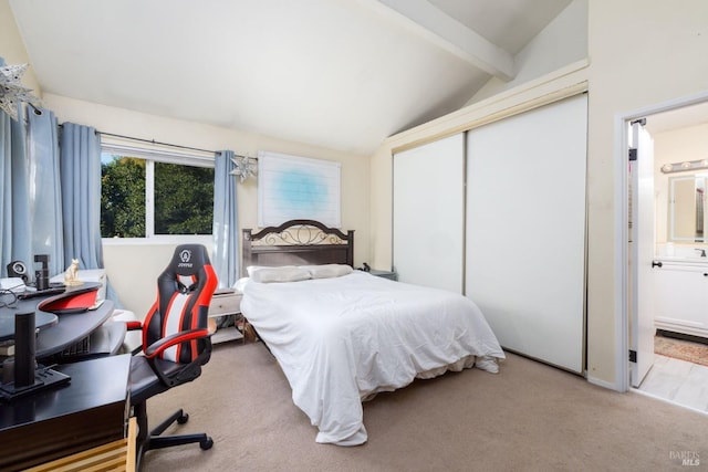 bedroom featuring lofted ceiling with beams, a closet, carpet flooring, and ensuite bathroom