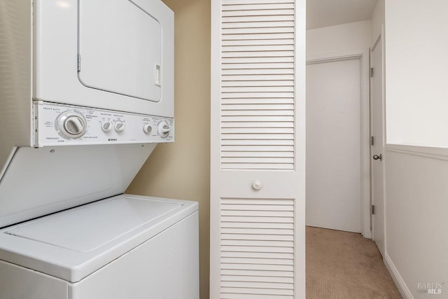 clothes washing area with light carpet, stacked washer / drying machine, and laundry area